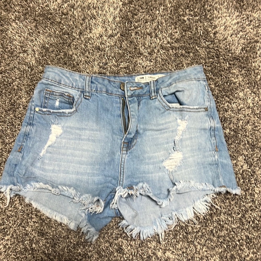 Light-washed high-waisted shorts. Distress detailing